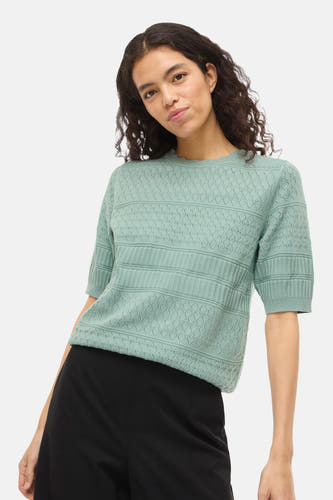Pull vert avec col rond de VILA, avec motif tricoté et manches courtes, combiné avec un pantalon noir.