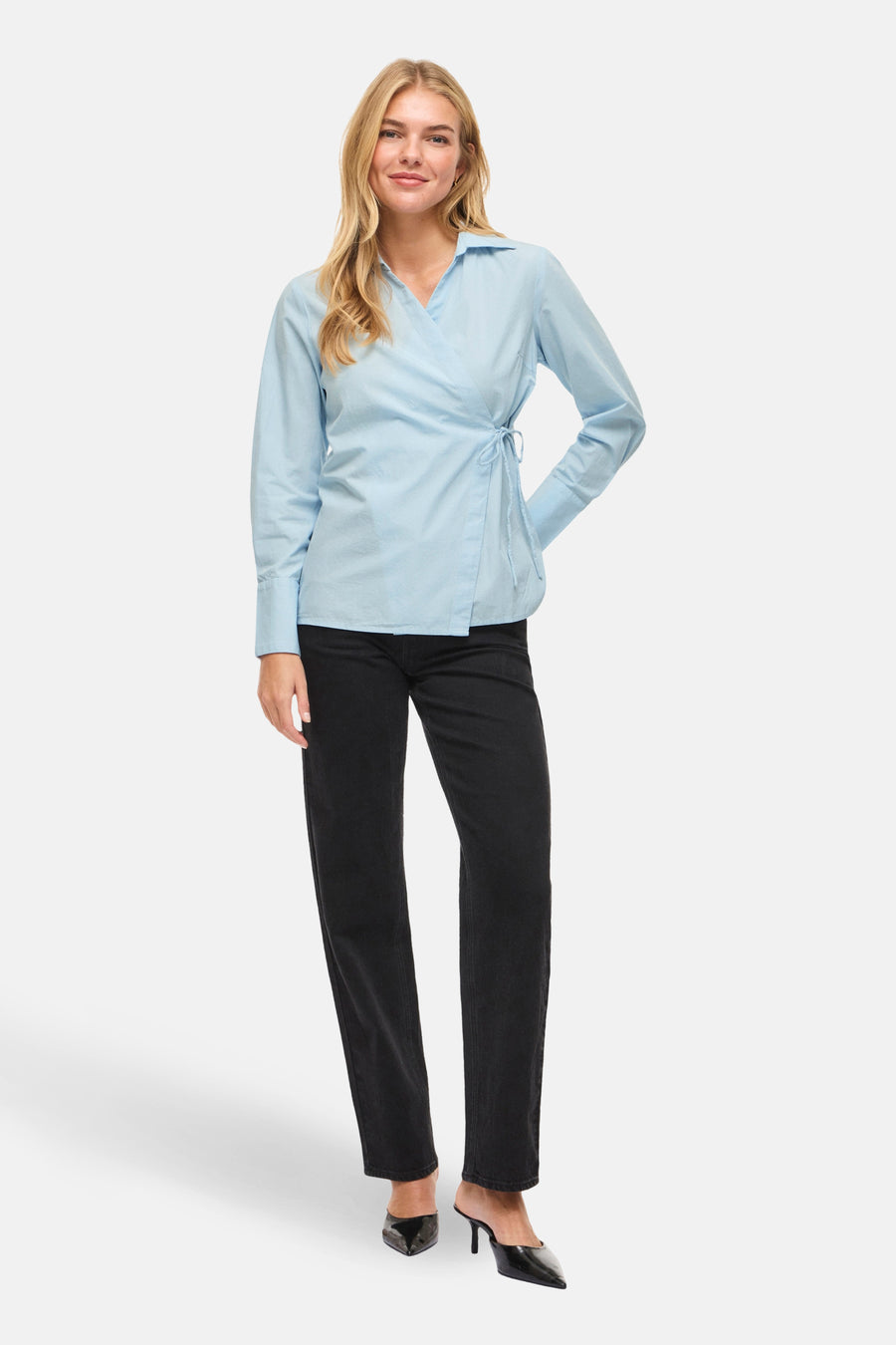 Blauw overhemd met lange mouwen van VILA®, met wikkeldetail aan de zijkant, gedragen met een zwarte broek en hakken.