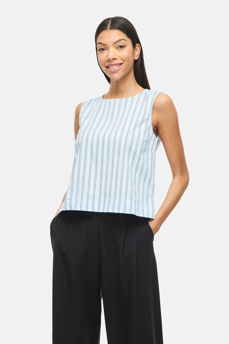 Chemisier bleu sans manches de VILA®, avec des rayures verticales et combiné avec un pantalon noir et des talons.