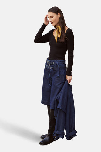 Shorts en denim bleu marine de VILA, avec une large cece, associé à un haut noir et des bottes.