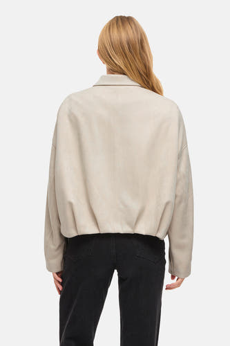 Manteau court beige de VILA, vu de dos, avec un jean noir.