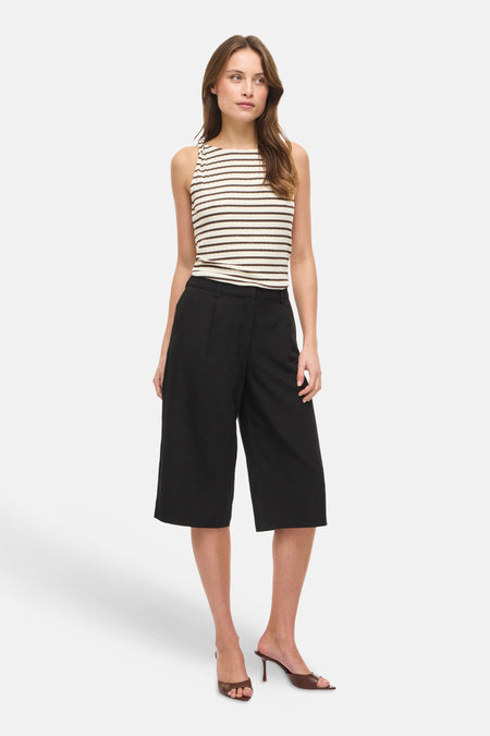 Mouwloze geribbelde gestreepte top in crème en bruin van VILA®, gecombineerd met zwarte culottes en bruine muiltjes.
