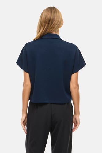Blauwe sweater van VILA, achterkant gezien, gecombineerd met een zwarte broek.
