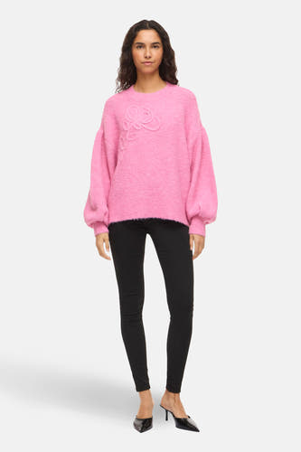 Roze trui met ronde hals van Vila met bloemmotief en pofmouwen, gedragen met zwarte broek en muiltjes.
