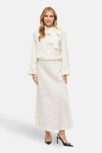 Lange ecru rok van VILA®, met zwarte stippen en gecombineerd met een bijpassende blouse en zwarte hakken.
