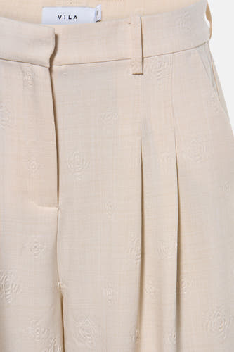 Pantalon beige de VILA avec motif floral subtil et plis sur le devant.