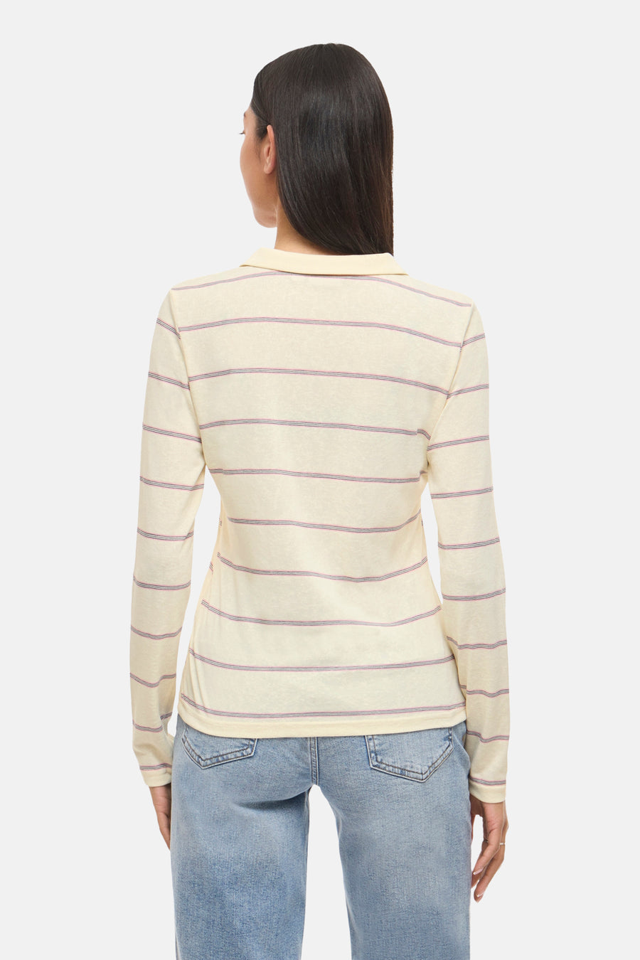 Crèmekleurige T-shirt met lange mouwen van VILA®, gestreept met paarse lijnen, gedragen met een blauwe jeans.
