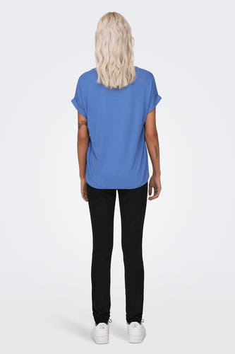 Blauw T-shirt van ONLY, met korte mouwen en omgeslagen mouwuiteinden, gedragen met zwarte broek en witte sneakers.