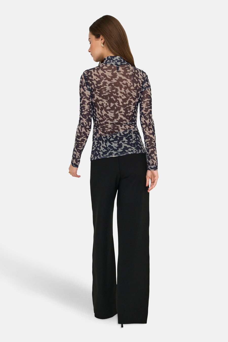 Multikleurige coltrui van ONLY, met een abstract camouflagepatroon, gecombineerd met een zwarte, wijde pantalon.
