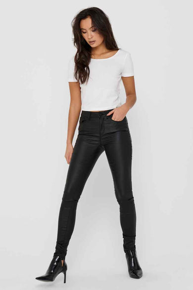 Zwarte broek van ONLY, met een glanzende afwerking, gecombineerd met een wit shirt en zwarte laarsjes.
