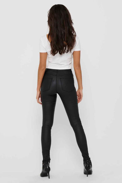 Zwarte broek van ONLY, getoond op de rug, gecombineerd met een wit shirt en zwarte laarzen.