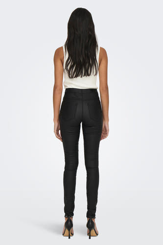 Pantalon noir de ONLY, avec des pinces flatantes et porté avec un haut blanc et des baskets noires.