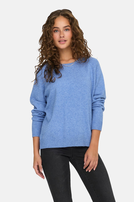 Blauwe trui met ronde hals van ONLY, met lange mouwen, geribbelde boorden en gedragen met een zwarte jeans.
