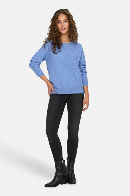 Blauwe trui met ronde hals van ONLY, met lange mouwen, gecombineerd met zwarte skinny jeans en laarzen.