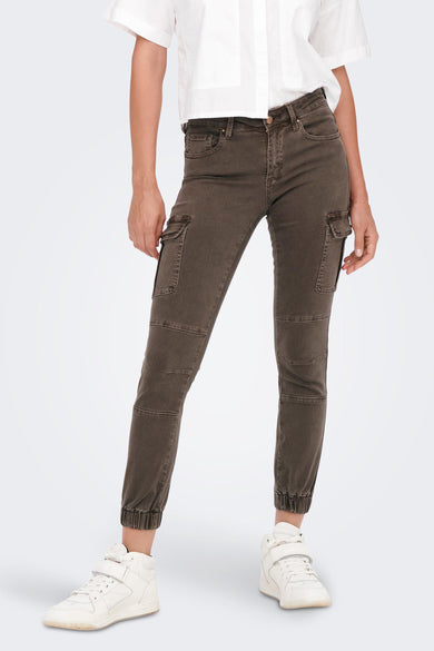 Bruine broek van ONLY, met cargo zakken en elastische boorden, gedragen met een wit shirt en witte sneakers.
