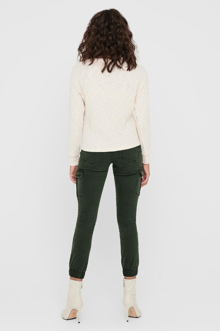 Grijskleurige broek van ONLY, met cargozakken en gedragen met een gebreide top en laarsjes met hak.
