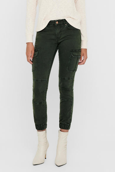 Grijze broek van ONLY, met cargo zakken en stiksels, gecombineerd met een gebreide trui en witte laarzen.
