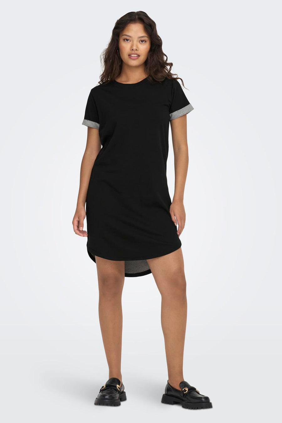 Robe noire à manches courtes de JDY, avec une ligne d'asymétrie et associée à des collants noirs.
