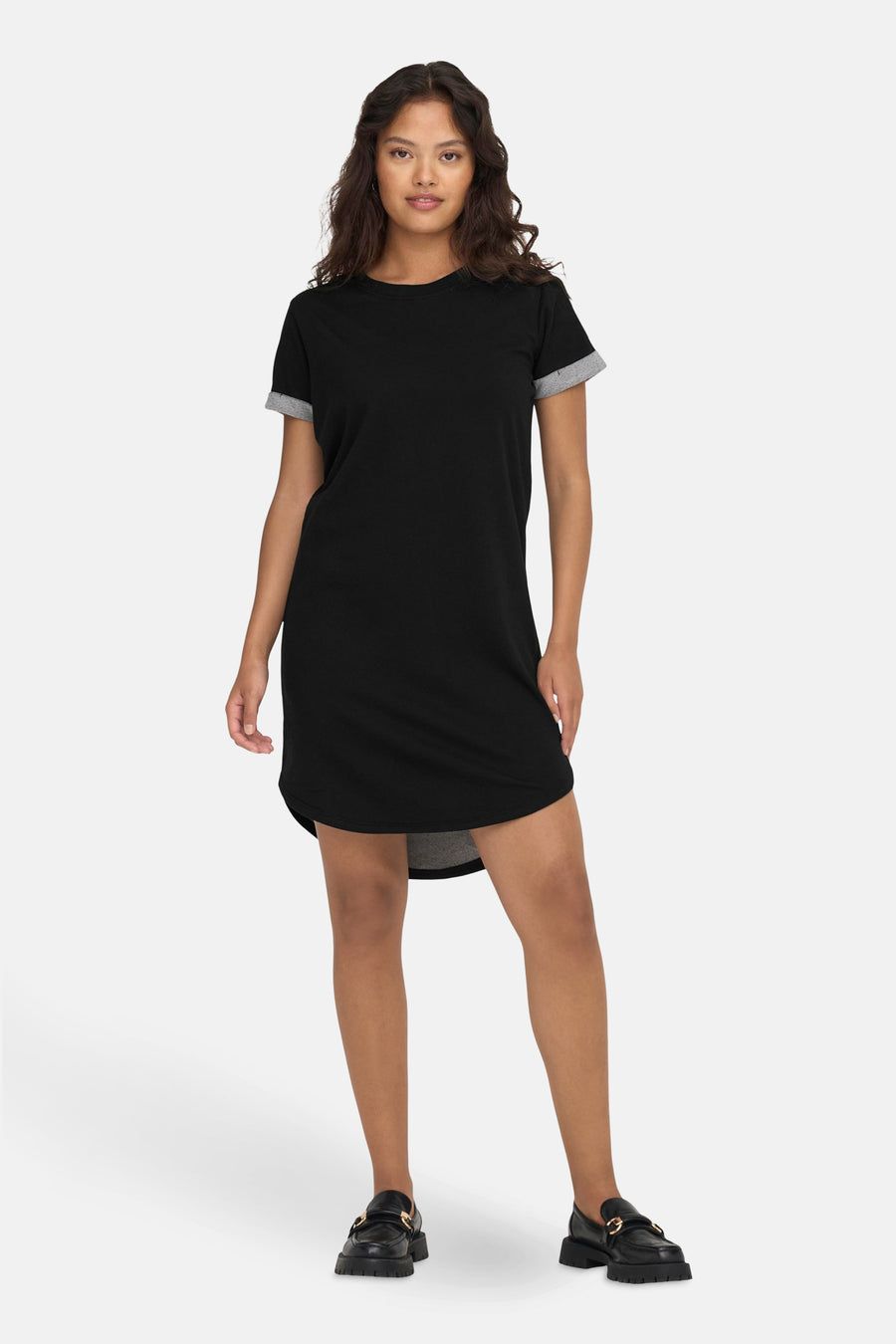 Robe noire à manches courtes de JDY, avec des manches retroussées et des chaussures noires.