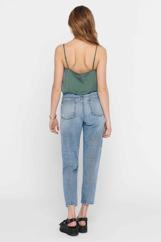Groene mouwloze blouse van ONLY, met spaghettibandjes, gecombineerd met een blauwe jeans en zwarte sandalen.