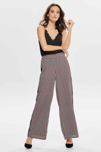 Zwarte mouwloze blouse van ONLY, met een geschulpte halslijn, gedragen met een broek met geometrisch patroon.
