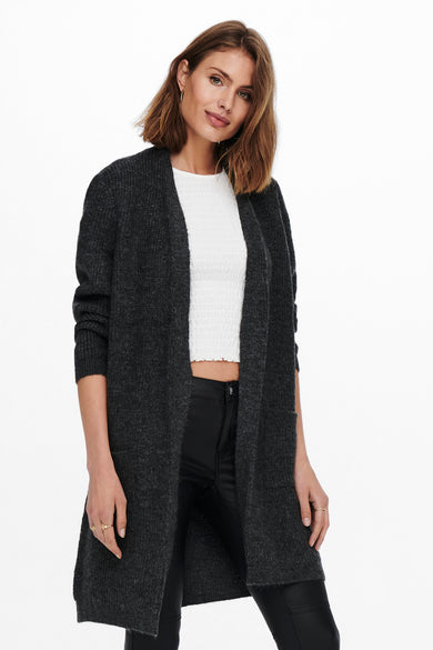Grijze gilet van ONLY, met lange mouwen en open voorkant, gecombineerd met een witte top en zwarte broek.
