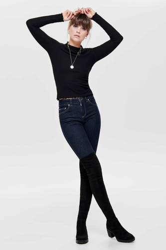 Pull noir ONLY, avec des manches longues, associé à des jeans foncés et des baskets noires à talon.