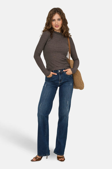 Pull marron avec col rond ONLY, à longues manches, associé à un pantalon de travail bleu et une sac tressé.