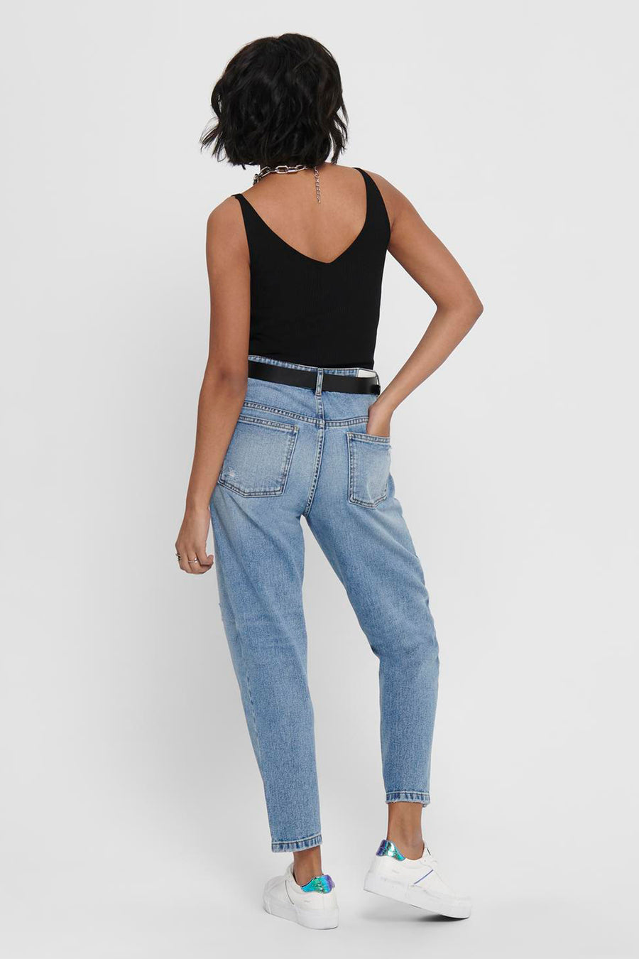 T-shirt noir de JDY, avec un col V et porté avec une chaîne d'argent et des jeans légers.