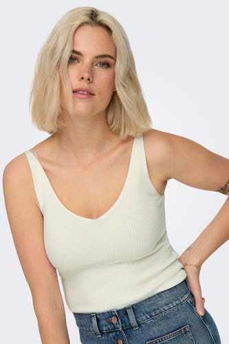 Witte tanktop van JDY, gedragen met een blauwe jeans en gouden armband.