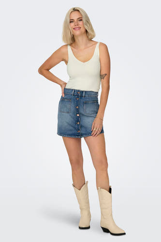 Witte tanktop van JDY, gedragen met een denim rok met knopen en beige laarzen.
