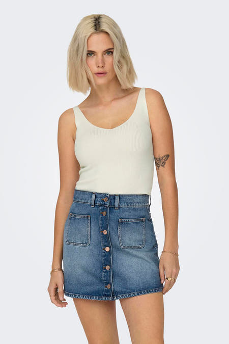 Débardeur blanc JDY, avec une texture tricotée rib, porté avec une robe en denim.