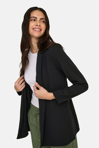 Zwarte blazer van JDY, gedragen met een wit T-shirt en groene joggingbroek.