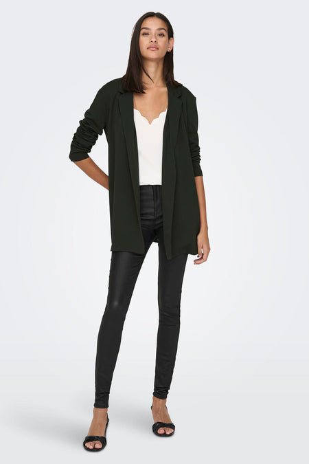 Bruine blazer van JDY, gedragen over een witte top en een zwarte broek, met hakken.
