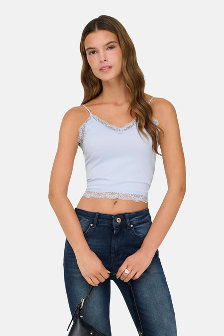 Blauwe beha van ONLY® met kanten details, gedragen met een donkere jeans en een zwarte tas.
