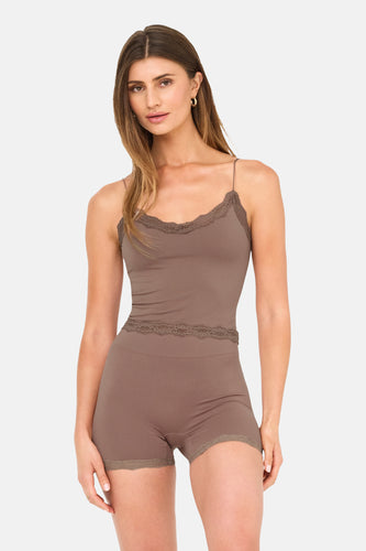 Vrouw in bruine lingerie-set met kanten details.