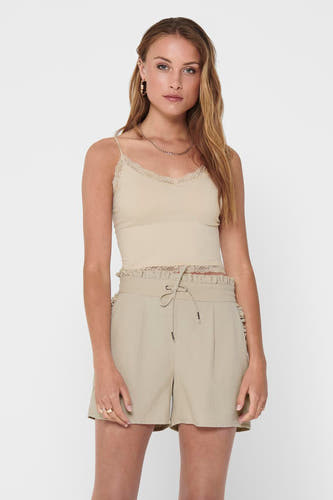 Ecru beha van ONLY, afgewerkt met kanten details, gedragen met gouden ketting en beige shorts.