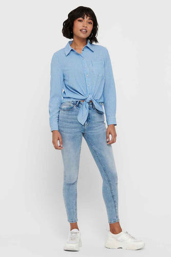 Wit gestreept hemd met lange mouwen van ONLY, geknoopt aan de voorkant, met jeans en witte sneakers.