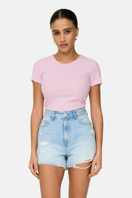 T-shirt rose à manches courtes de ONLY, avec une texture côtelée, porté avec un short en denim et des baskets blanches.