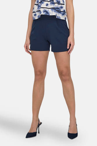 Blauwe short van JDY, gecombineerd met een bloemenprint top en donkerblauwe pumps.