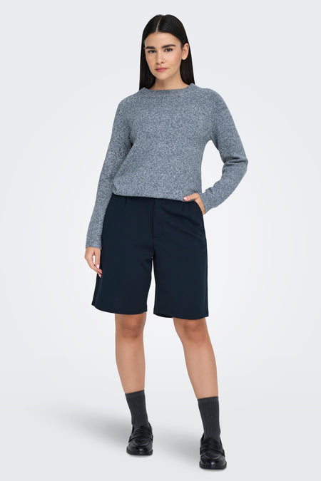 Blauwe trui met ronde hals van ONLY®, gedragen met zwarte shorts, sokken en loafers.