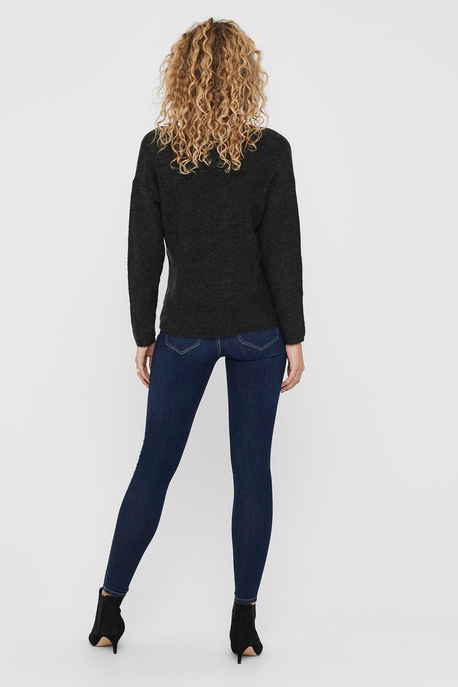 Sweat-shirt V-hals gris ONLY, avec des manches longues, associé à des jeans foncés et des escarpins noirs, vue arrière.