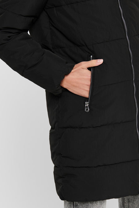 Zwarte lange jas van ONLY, met gewatteerd ontwerp en hand in zak.
