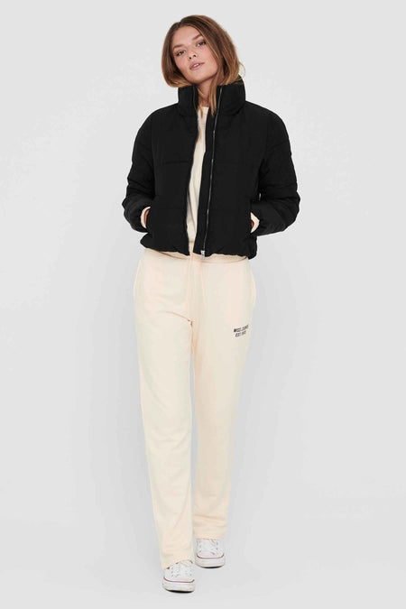 Zwarte korte jas van ONLY, met een ritssluiting en steekzakken, gecombineerd met een sweater en joggingbroek.