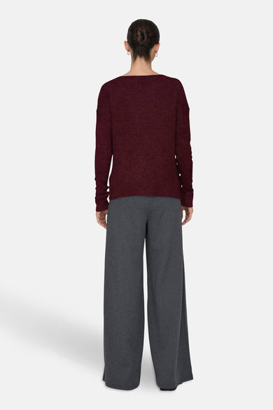 Bordeaux trui met ronde hals van JDY, gezien van achteren met grijze broek.