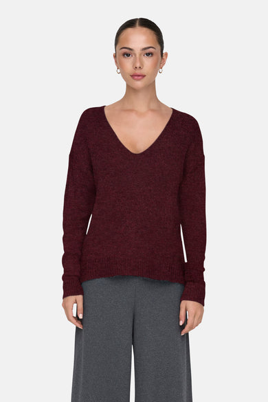 Bordeaux trui met ronde hals van JDY, met lange mouwen en gecombineerd met een grijze broek.
