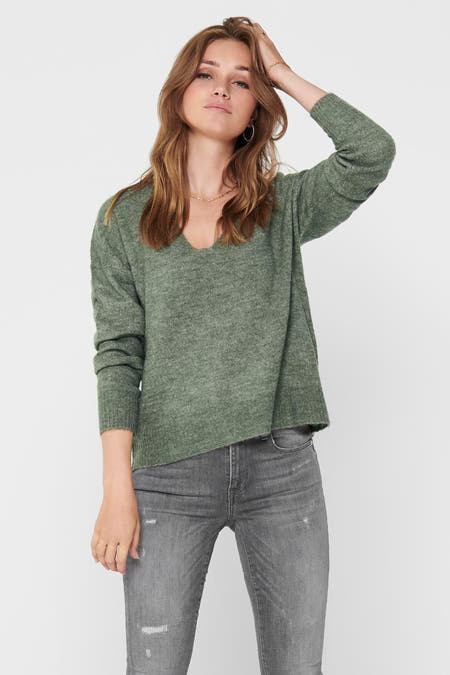 Groene trui met ronde hals van JDY, gedragen met grijze jeans en gouden sieraden.
