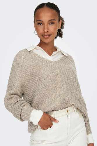 Pull à col V marron de JDY, porté sur une chemise blanche et associé à un pantalon crème.