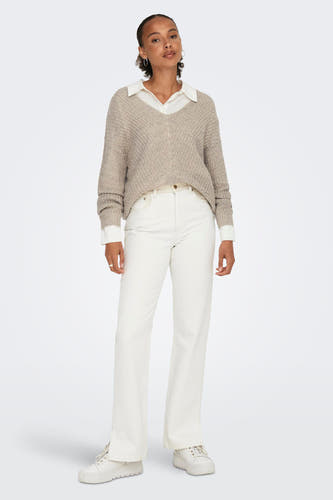 Pull à col V marron de JDY, associé à une chemise blanche, un pantalon blanc et des chaussures blanches.