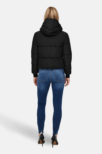 Manteau court noir de JDY, avec un capuchon et associé à des jeans noirs et des baskets noires.